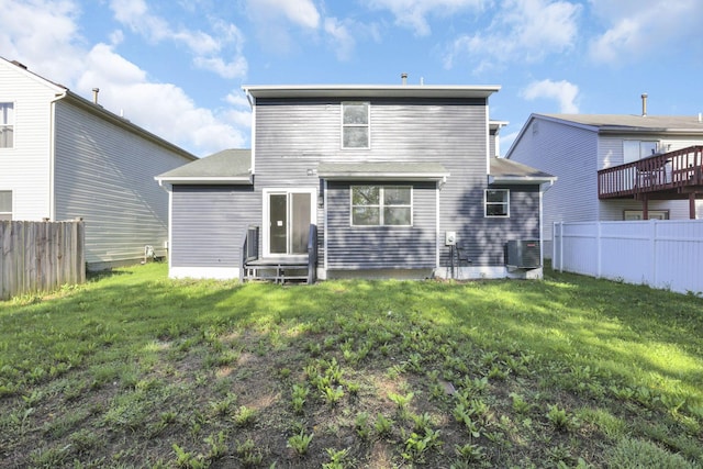 rear view of property featuring central AC and a yard