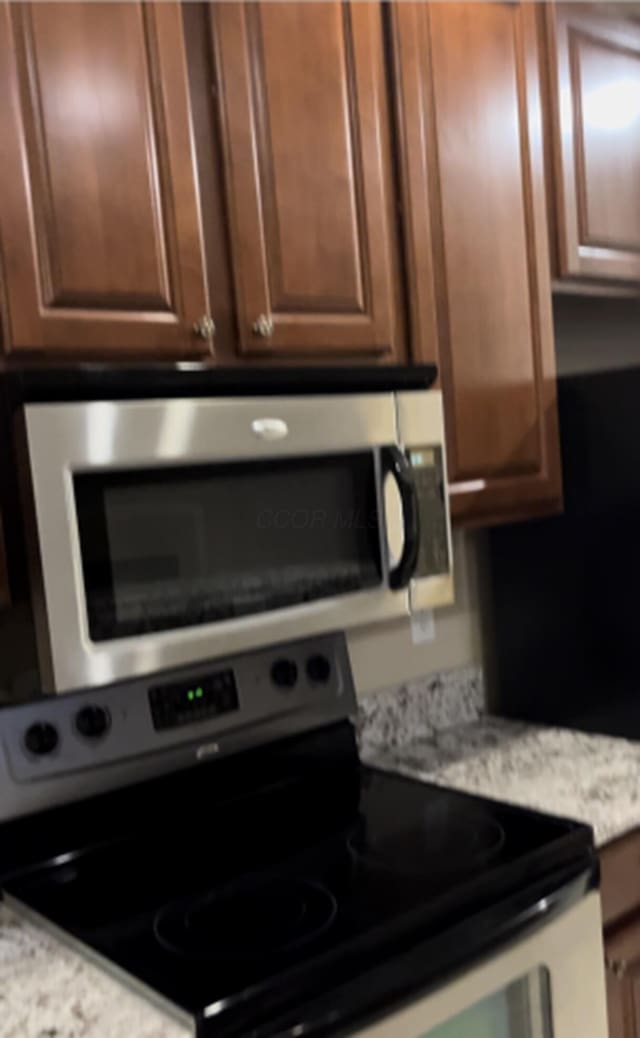 kitchen featuring light stone counters and appliances with stainless steel finishes