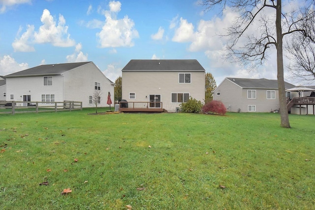 rear view of house with a yard and a wooden deck