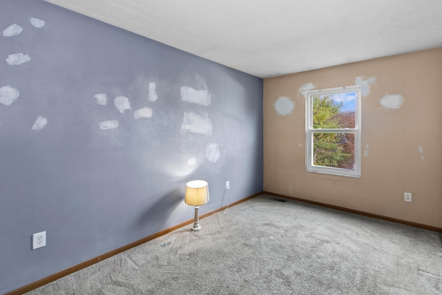 carpeted empty room with a textured ceiling