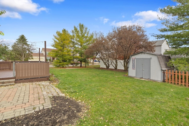 view of yard featuring a wooden deck and a storage unit