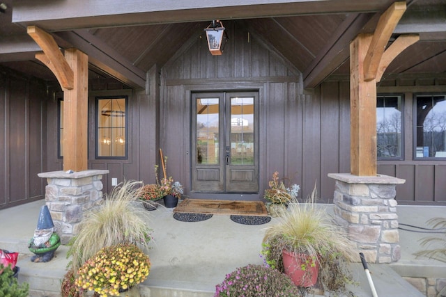 view of exterior entry featuring covered porch and french doors