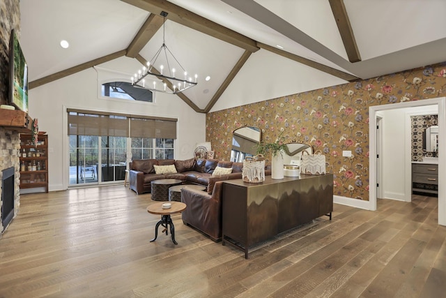 living room featuring a stone fireplace, high vaulted ceiling, beamed ceiling, a notable chandelier, and hardwood / wood-style floors