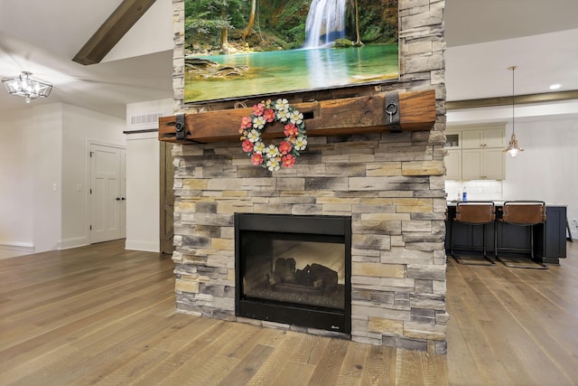 room details featuring a fireplace, wood-type flooring, and beamed ceiling