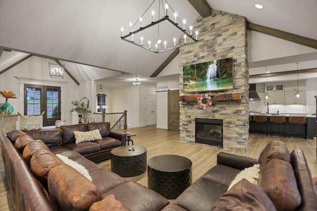 living room featuring a stone fireplace, beamed ceiling, high vaulted ceiling, and light wood-type flooring