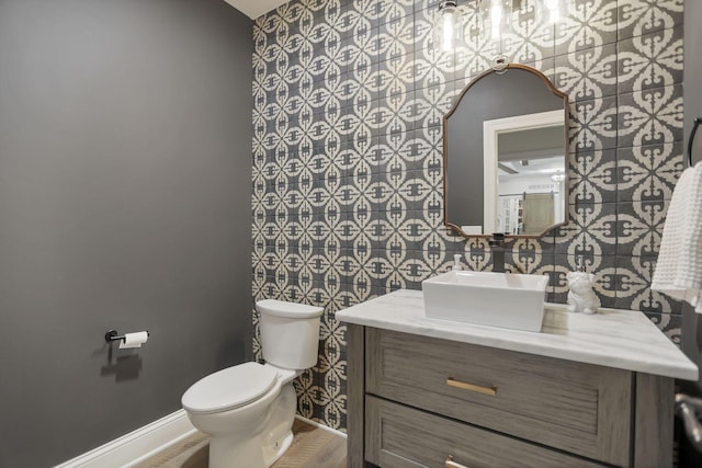 bathroom featuring vanity, toilet, and tile walls