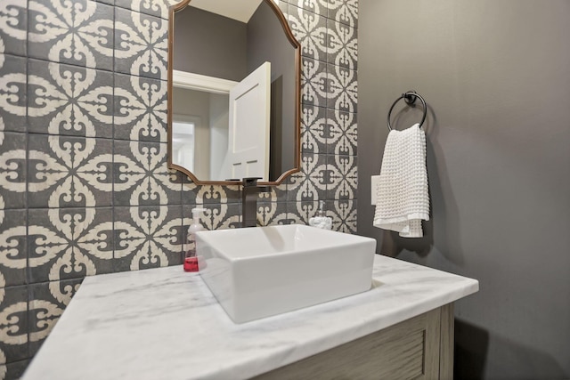 bathroom with decorative backsplash, vanity, and tile walls