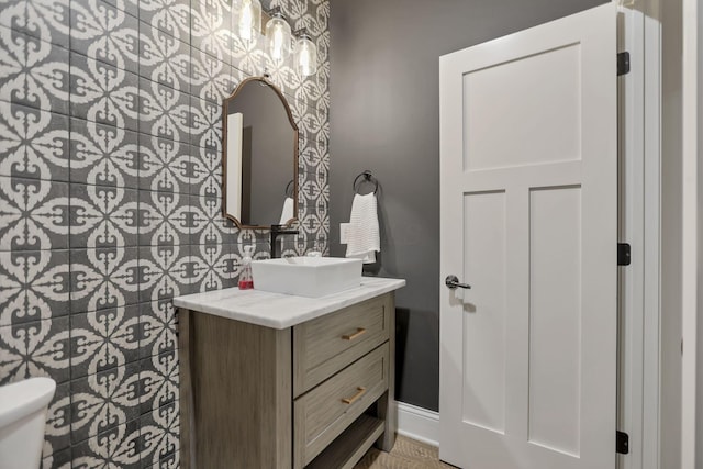 bathroom featuring vanity, tile walls, and toilet