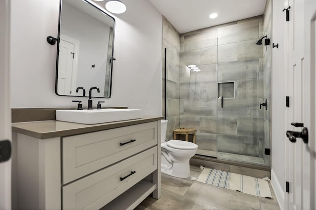 bathroom featuring vanity, toilet, and a shower with shower door