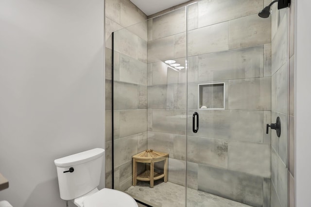 bathroom with toilet and a shower with shower door