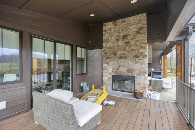 wooden terrace featuring an outdoor stone fireplace