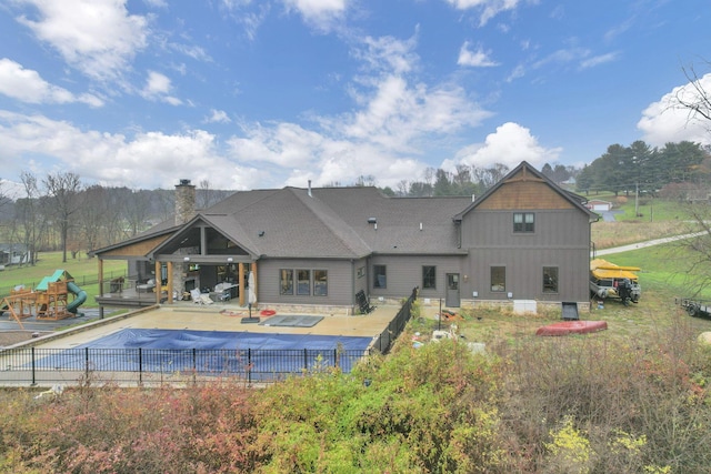 rear view of house with a patio and a covered pool