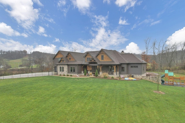 craftsman house with a playground and a front lawn