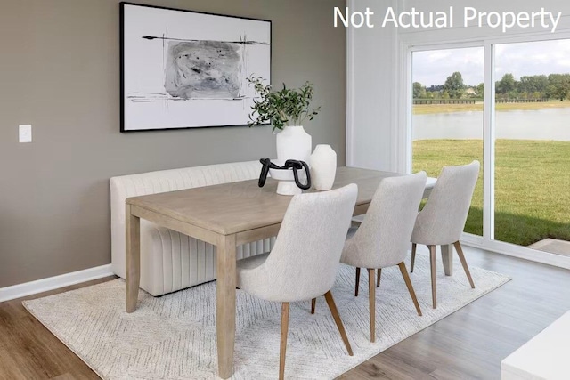 dining area with a water view and hardwood / wood-style flooring