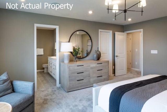 carpeted bedroom featuring a chandelier and connected bathroom