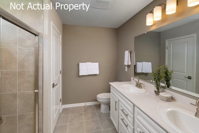 bathroom with tile patterned floors, a shower with door, vanity, and toilet