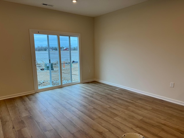 empty room with a water view and light hardwood / wood-style floors