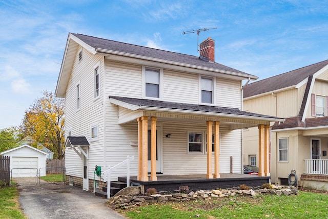 view of front facade featuring an outdoor structure, a porch, and a garage