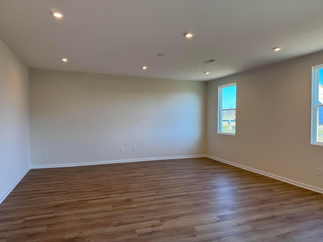 unfurnished room featuring a wealth of natural light and light hardwood / wood-style floors