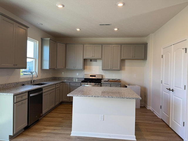 kitchen with a center island, sink, light hardwood / wood-style floors, and stainless steel appliances