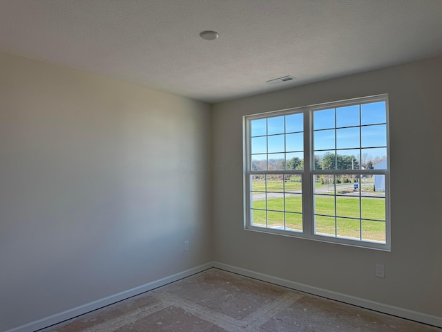 spare room featuring a textured ceiling and a wealth of natural light