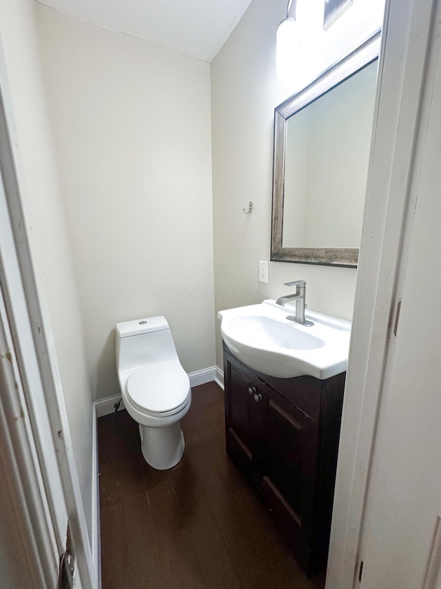 bathroom with vanity, wood-type flooring, and toilet