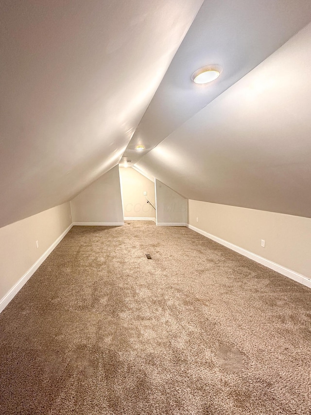 bonus room with lofted ceiling and carpet floors