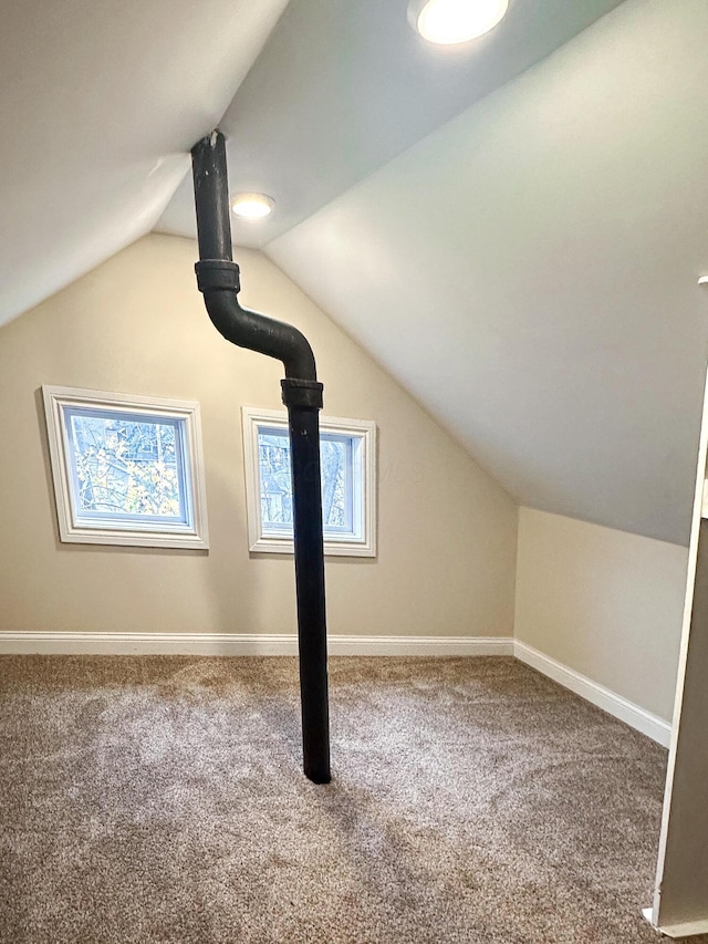 additional living space featuring carpet floors and vaulted ceiling