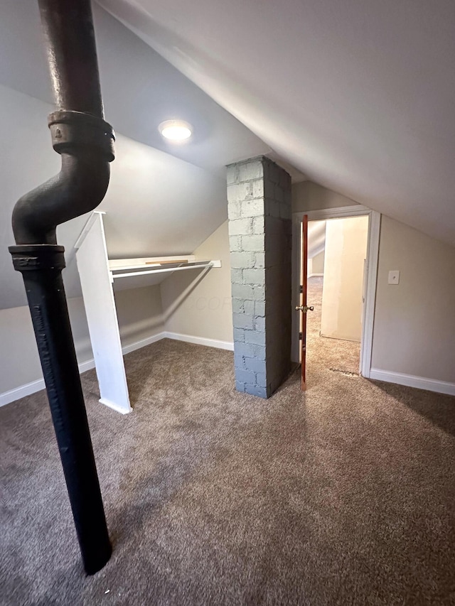 additional living space featuring dark carpet and lofted ceiling