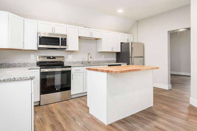 kitchen featuring wood counters, a center island, white cabinets, light hardwood / wood-style floors, and stainless steel appliances