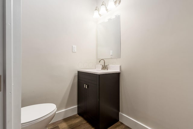 bathroom featuring vanity, hardwood / wood-style flooring, and toilet