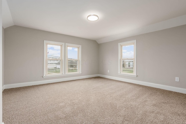 empty room with carpet flooring and lofted ceiling