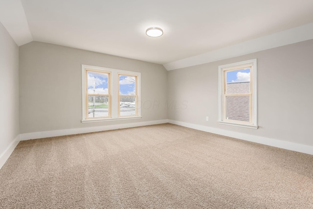 carpeted spare room with lofted ceiling