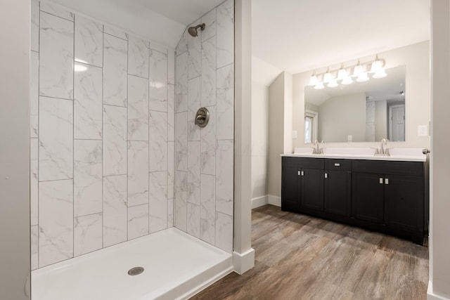 bathroom featuring tiled shower, wood-type flooring, and vanity