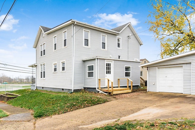 back of property featuring a garage and an outbuilding