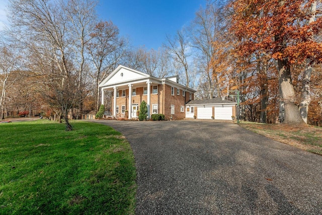 greek revival inspired property with an outbuilding, a garage, and a front yard