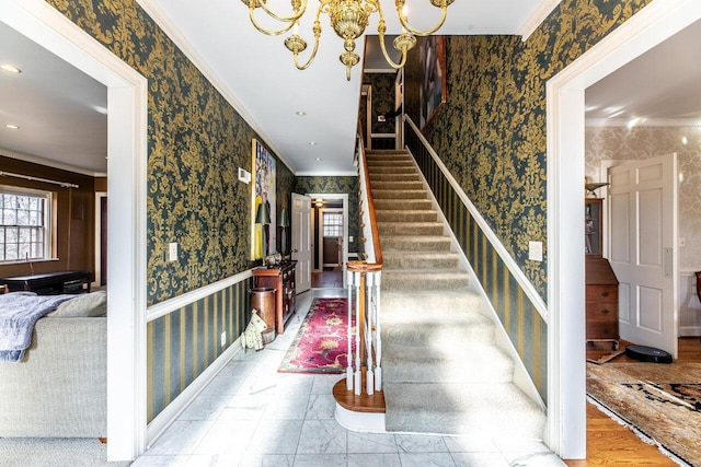 staircase with crown molding and an inviting chandelier