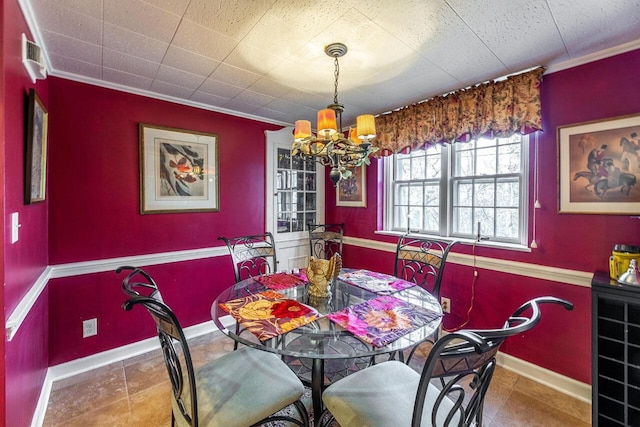 dining space with crown molding and a chandelier