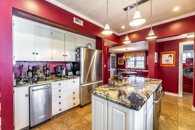 kitchen featuring white cabinets, dark stone countertops, decorative light fixtures, a kitchen island, and stainless steel appliances