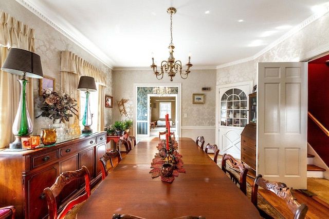 dining area with light hardwood / wood-style floors, crown molding, and a notable chandelier