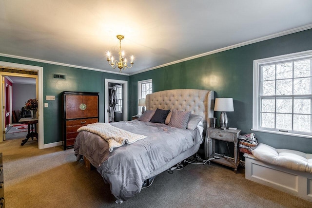 carpeted bedroom featuring a walk in closet, crown molding, a closet, and a chandelier