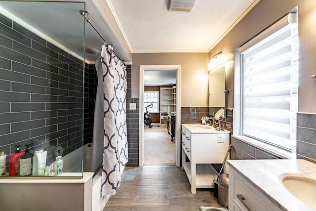 bathroom featuring shower / bath combo, wood-type flooring, vanity, tile walls, and ornamental molding