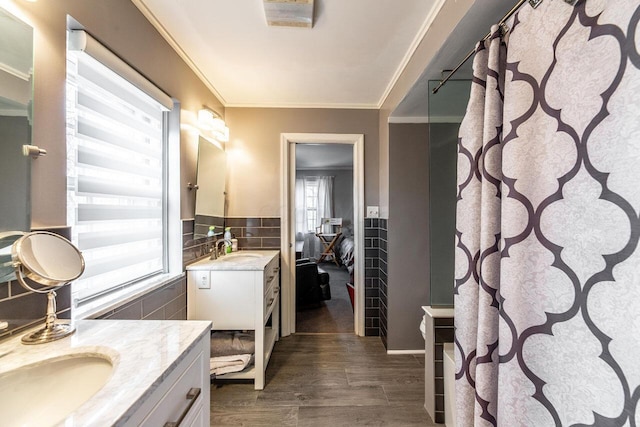 bathroom with hardwood / wood-style flooring, vanity, ornamental molding, and tile walls