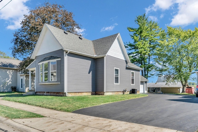 view of property exterior with a lawn and central AC unit