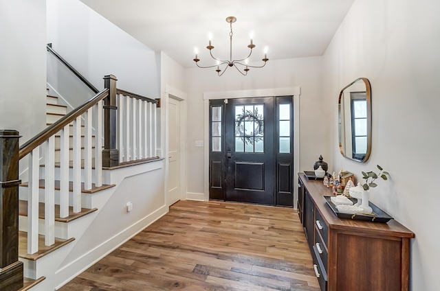 entryway with hardwood / wood-style floors and a notable chandelier