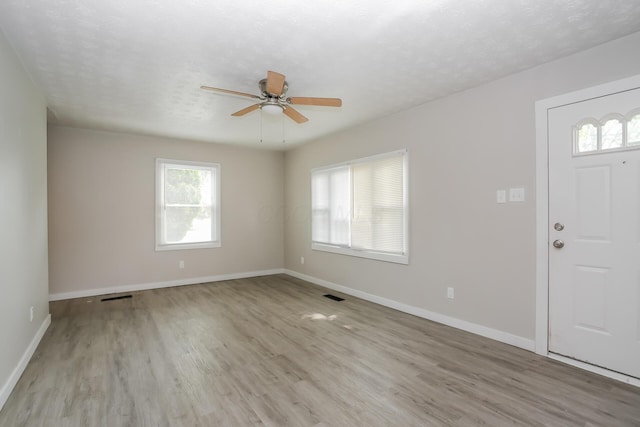 foyer with ceiling fan, light hardwood / wood-style flooring, and a textured ceiling