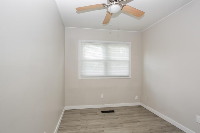 empty room with ceiling fan and light hardwood / wood-style flooring