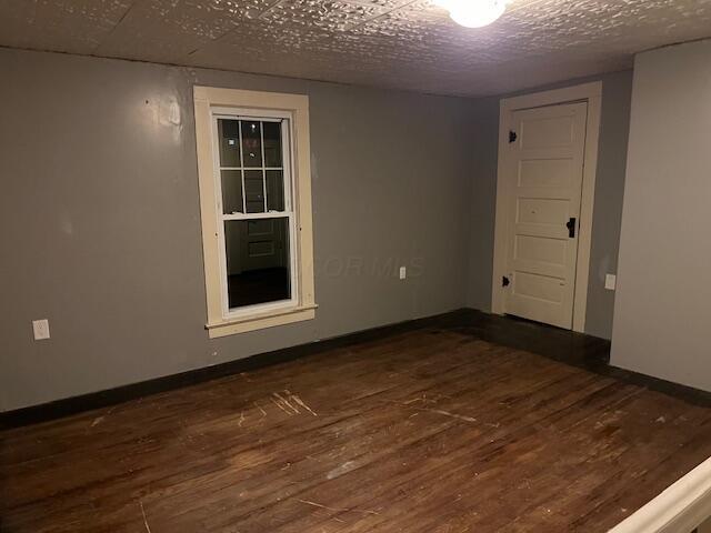 empty room featuring dark wood-type flooring and a textured ceiling