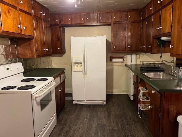 kitchen featuring white appliances, backsplash, dark wood-type flooring, and sink