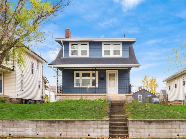 view of front of home with a porch and a front lawn